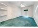 Spacious bedroom with teal carpet and built-in shelving at 5666 Merlin Way, St Cloud, FL 34772