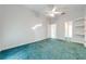 Large bedroom with teal carpet and access to bathroom at 5666 Merlin Way, St Cloud, FL 34772