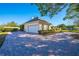 Attached garage with a spacious driveway and lush landscaping at 5666 Merlin Way, St Cloud, FL 34772