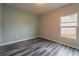 Bedroom with gray and teal walls, wood-look flooring, and a window at 1067 Haines Dr, Winter Haven, FL 33881