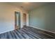 Bedroom with gray and teal walls, wood-look flooring, and access to another room at 1067 Haines Dr, Winter Haven, FL 33881