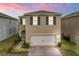 Two-story house with a white garage door and blue shutters at 113 Eagleview Loop, Davenport, FL 33837