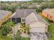 Aerial view of single-story house with landscaped yard and paver driveway at 119 Verona Dr, Kissimmee, FL 34759