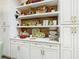 White kitchen cabinets with wood shelving, displaying decorative plates and kitchenware at 119 Verona Dr, Kissimmee, FL 34759