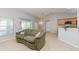 Living room with a green sofa and view of the kitchen at 1608 Nectarine Trl, Clermont, FL 34714