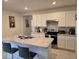 Modern kitchen with white cabinets, island, and stainless steel appliances at 1657 Rosydale Cir, Davenport, FL 33837