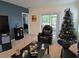 Spacious living room with large TV, comfortable seating, and a cozy Christmas tree at 1657 Rosydale Cir, Davenport, FL 33837