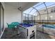 Enclosed pool area with foosball table and lounge chairs at 2137 Pine Oak Loop, Davenport, FL 33837
