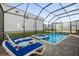 Screened-in pool and spa with lounge chairs at 2137 Pine Oak Loop, Davenport, FL 33837