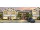 Tan two-story condo building with balconies and palm trees at 2317 Prime Cir # B, Kissimmee, FL 34746