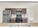 Modern kitchen with dark cabinets, stainless steel appliances, and granite countertops at 2317 Prime Cir # B, Kissimmee, FL 34746