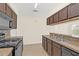 Modern kitchen with dark cabinets, stainless steel appliances, and granite countertops at 2317 Prime Cir # B, Kissimmee, FL 34746