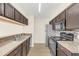 Modern kitchen with dark wood cabinets and granite counters at 2317 Prime Cir # B, Kissimmee, FL 34746