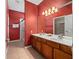 Bright red bathroom with a double sink vanity and walk-in shower at 2615 Pawnall St, Kissimmee, FL 34747