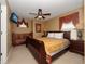Bedroom with a dark wood bed, crib, ceiling fan, and a window with decorative curtains at 2615 Pawnall St, Kissimmee, FL 34747