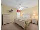 Cozy bedroom featuring a queen bed, matching nightstands, and a tropical-themed ceiling fan at 2615 Pawnall St, Kissimmee, FL 34747