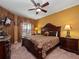 This is a bedroom with a dark wood bed set, large lamps, a ceiling fan, and carpeted floors at 2615 Pawnall St, Kissimmee, FL 34747
