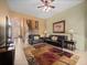 Open-concept living room with tile floors, staircase, black leather couches, and large patterned rug at 2615 Pawnall St, Kissimmee, FL 34747