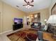Bright living room with tile floors, black couches, television, and view into the kitchen at 2615 Pawnall St, Kissimmee, FL 34747