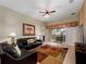 Comfortable living room with tile floors, black leather couches, ceiling fan and sliding door to patio at 2615 Pawnall St, Kissimmee, FL 34747