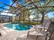 Inviting screened pool and spa area with brick pavers and several lounge chairs at 2615 Pawnall St, Kissimmee, FL 34747