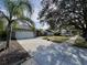 House with a long paved driveway and mature trees at 31 Augusta Cir, St Cloud, FL 34769