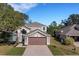 Two-story house with brown garage door and tree-lined street at 336 Del Sol Ave, Davenport, FL 33837