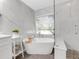 Spa-like bathroom with soaking tub, walk-in shower, and marble tile at 336 Del Sol Ave, Davenport, FL 33837