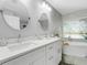 Modern bathroom with double vanity, white cabinets and soaking tub at 336 Del Sol Ave, Davenport, FL 33837