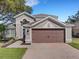 Two-story house with brown garage door and landscaped yard at 336 Del Sol Ave, Davenport, FL 33837