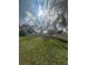 Large backyard with grassy area and trees at 520 Carlsbad Dr, Kissimmee, FL 34758
