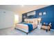 King-size bed, blue accent wall, and ample space at 607 Longboat Dr, Davenport, FL 33896