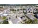 Community aerial view highlighting rooftops, lush trees, and neighborhood streets near a lake at 6826 Goldflower Ave, Harmony, FL 34773