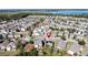Aerial view of a house with a pond and lush greenery in the background at 6826 Goldflower Ave, Harmony, FL 34773