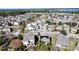 Aerial view of a community showcasing rooftops, landscaping, and a glimpse of a lake at 6826 Goldflower Ave, Harmony, FL 34773