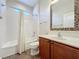 Well-lit bathroom with tiled shower and tub, mosaic mirror, and vanity with storage at 6826 Goldflower Ave, Harmony, FL 34773