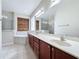 Bathroom with double vanity, soaking tub, glass shower, and wood accent wall at 6826 Goldflower Ave, Harmony, FL 34773