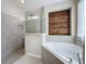 Beautiful bathroom featuring a soaking tub, glass shower, and decorative accent wall at 6826 Goldflower Ave, Harmony, FL 34773