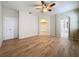 Spacious bedroom featuring wood floors, a ceiling fan, and access to a walk-in closet and ensuite bathroom at 6826 Goldflower Ave, Harmony, FL 34773