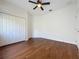 Bedroom featuring wood floors, a ceiling fan, closet, and door leading outside at 6826 Goldflower Ave, Harmony, FL 34773