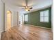 Spacious bedroom with wood flooring, a ceiling fan, and plantation shutters at 6826 Goldflower Ave, Harmony, FL 34773