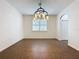 An inviting dining room has neutral walls, tile floors, and a statement chandelier under a bright window at 6826 Goldflower Ave, Harmony, FL 34773