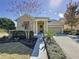 Beautiful tan house with a two car garage, walkway, and landscaping at 6826 Goldflower Ave, Harmony, FL 34773