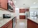 Kitchen with stainless steel appliances, granite countertops, and tile flooring at 6826 Goldflower Ave, Harmony, FL 34773