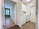 A fully equipped laundry room features a modern washer, dryer, storage cabinets, and convenient exterior door at 6826 Goldflower Ave, Harmony, FL 34773
