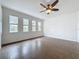 This is a bright living room featuring tiled flooring, a ceiling fan, and a wall of sunny windows at 6826 Goldflower Ave, Harmony, FL 34773
