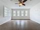 This spacious living room features tile floors, ceiling fan, and lots of bright light from the windows at 6826 Goldflower Ave, Harmony, FL 34773