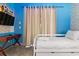 Blue bedroom with a twin bed, desk, and TV at 7617 Wilmington Loop, Kissimmee, FL 34747