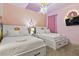 A princess-themed bedroom with two twin beds and a TV at 7617 Wilmington Loop, Kissimmee, FL 34747