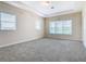 Large bedroom with carpet, neutral walls and large windows at 870 Spinnaker Way, Kissimmee, FL 34746